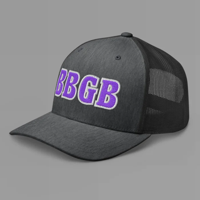 A dark heather grey hat with the letters "BBGB" embroidered on the front in purple thread, with a white border, on a trucker cap with a mesh back. (Left Side View)