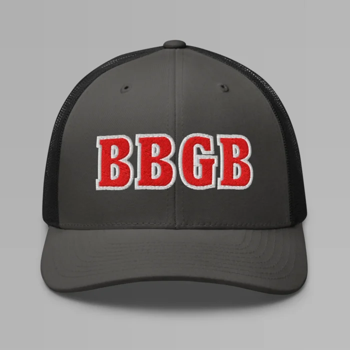 A charcoal and black hat with the letters "BBGB" embroidered on the front in red thread, with a white border, on a trucker cap with a mesh back.