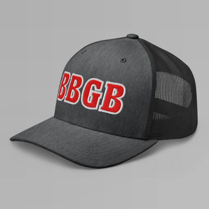 A dark heather grey hat with the letters "BBGB" embroidered on the front in red thread, with a white border, on a trucker cap with a mesh back. (Left Side View)