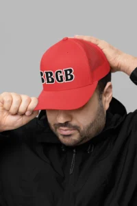 Male model wearing the BBGB Simple Trucker Hat - Black Edition and a red pull over coat.