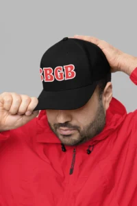 Male model wearing the BBGB Simple Trucker Hat - Red Edition and a red pull over coat.