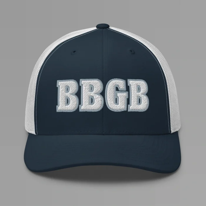 A navy and white hat with the letters "BBGB" embroidered on the front in white thread, with a silver border, on a trucker cap with a mesh back.