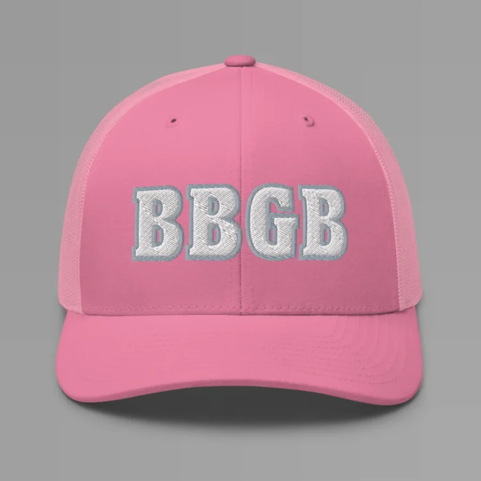 A pink hat with the letters "BBGB" embroidered on the front in white thread, with a silver border, on a trucker cap with a mesh back.