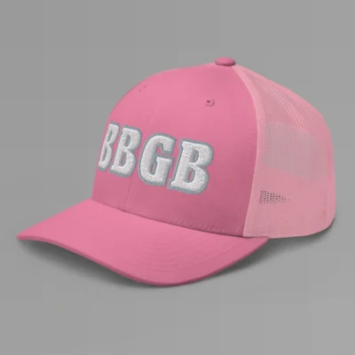 A pink hat with the letters "BBGB" embroidered on the front in white thread, with a silver border, on a trucker cap with a mesh back. (Left Side View)