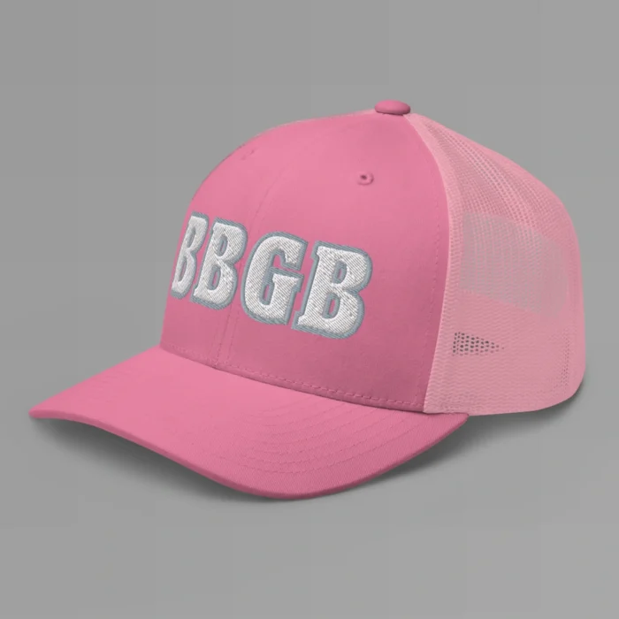 A pink hat with the letters "BBGB" embroidered on the front in white thread, with a silver border, on a trucker cap with a mesh back. (Left Side View)