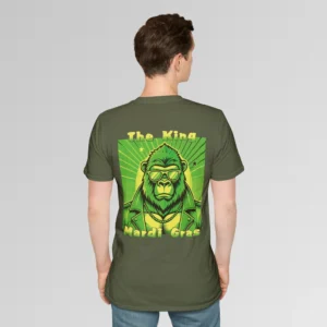 Male model in black t-shirt showing the back of a tee with a green and gold graphic of a swag looking gorilla bear character, wearing shades, with a sun behind it, in a retro style, and the words "The King" and "Mardi Gras" in a gradient colored yellow to green font.