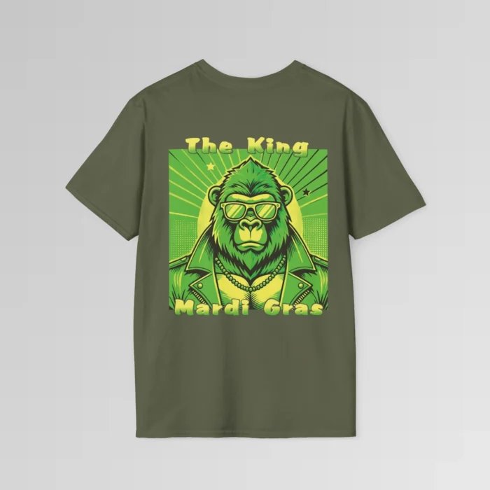 The backside of a military green colored tee with a swag looking gorilla bear wearing shades, with a sun like object with rays shooting out from behind the character. The words "The King" are above the graphic, and "Mardi Gras" beneath the graphic. The entire image is in varying shades of green and gold.