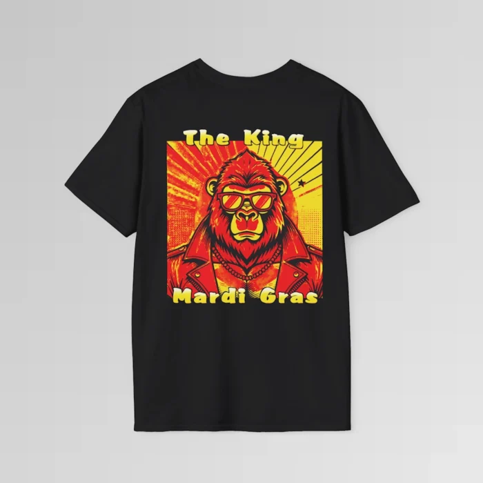 The backside of a black colored tee with a swag looking gorilla bear wearing shades, with a sun like object with rays shooting out from behind the character. The words "The King" are above the graphic, and "Mardi Gras" beneath the graphic. The entire image is in varying shades of red, yellow, and orange.