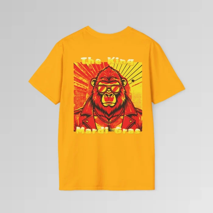 The backside of a gold colored tee with a swag looking gorilla bear wearing shades, with a sun like object with rays shooting out from behind the character. The words "The King" are above the graphic, and "Mardi Gras" beneath the graphic. The entire image is in varying shades of red, yellow, and orange.