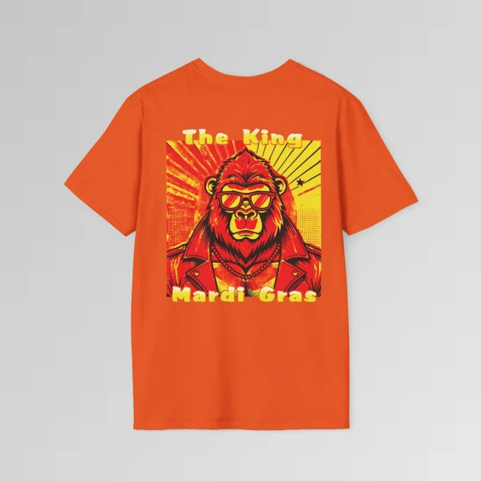 The backside of a orange colored tee with a swag looking gorilla bear wearing shades, with a sun like object with rays shooting out from behind the character. The words "The King" are above the graphic, and "Mardi Gras" beneath the graphic. The entire image is in varying shades of red, yellow, and orange.