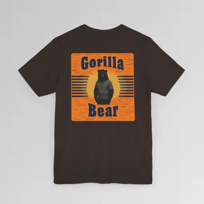 An orange and dark navy colored rectangular design on the back of a Big Baby Gorilla Bear Tee. Our Gorilla Bear Mascot Silhouette is in front of an orange and yellow sunset, with vertical blue lines on each side. The words "Gorilla" are at the top of the design, and "Bear" is at the bottom of the design. Shirt color - brown.