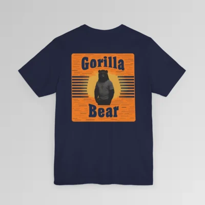 An orange and dark navy colored rectangular design on the back of a Big Baby Gorilla Bear Tee. Our Gorilla Bear Mascot Silhouette is in front of an orange and yellow sunset, with vertical blue lines on each side. The words "Gorilla" are at the top of the design, and "Bear" is at the bottom of the design. Shirt color - navy.