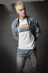 Male model in denim jeans, with a jean jacket, and a white "Low Verbosity" T-shirt from BigBabyGorillaBear.Com