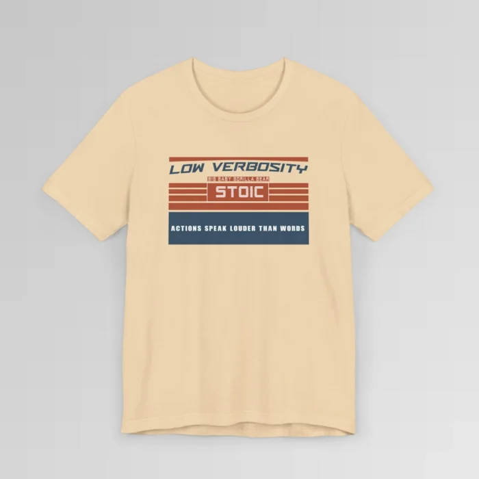An orange and blue rectangular graphic, block styled", with the words "Low Verbosity", "Big Baby Gorilla Bear", "Stoic", and "Actions Speak Louder Than Words" on the front of the t-shirt. Color; Soft Cream.