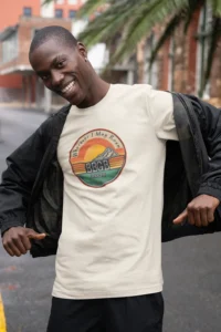 Male model showcasing the front of the "Wherever I May Roam Graphic Tee" from Big baby Gorilla Bear - Natural Color.