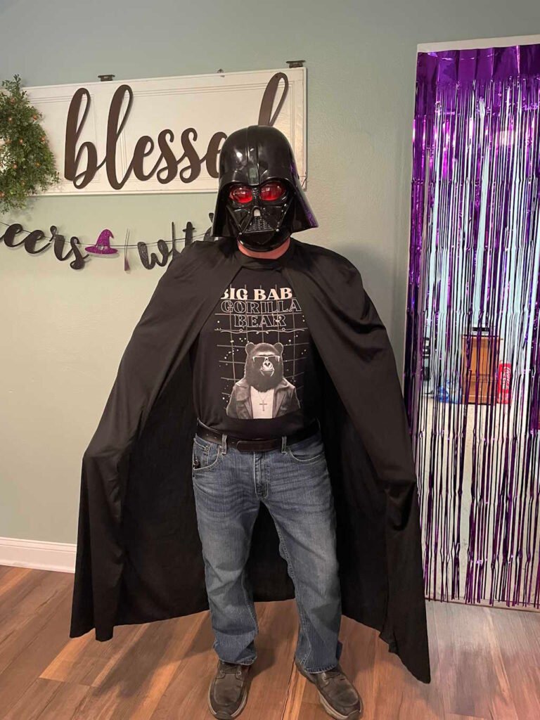 A person in a Big Baby Gorilla Bear Tee, and a Darth Vader costume.