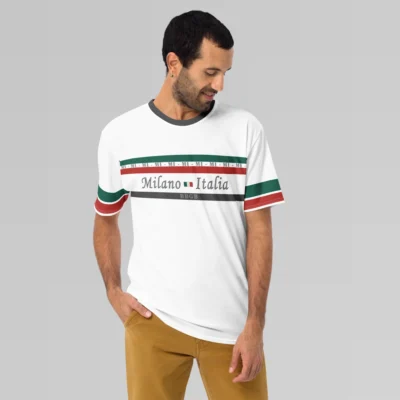 Male model looking left and downward, wearing a white, Milano Italia Luxurious Tee from BigBabyGorillaBear.Com. The shirt has green and red stripes, the letters "MI", and the words Milano and Italia centered around the Italian flag, with striped sleeves (red and green). There is a dark grey stripe with "BBGB" in the center on the bottom of the chest area.