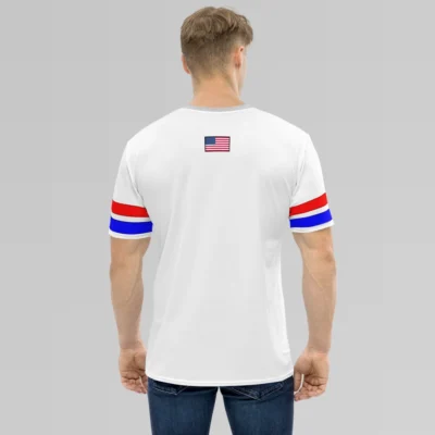 A male model showcasing the backside of the New York United States Luxurious Tee from BigBabyGorillaBear.Com. The shirt has a light grey collar, red and blue stripes on the sleeves with a black outline, and the American flag in the top, center of the tee.